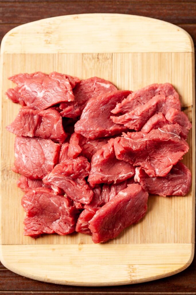 beef sliced on a cutting board for beef and broccoli stir fry