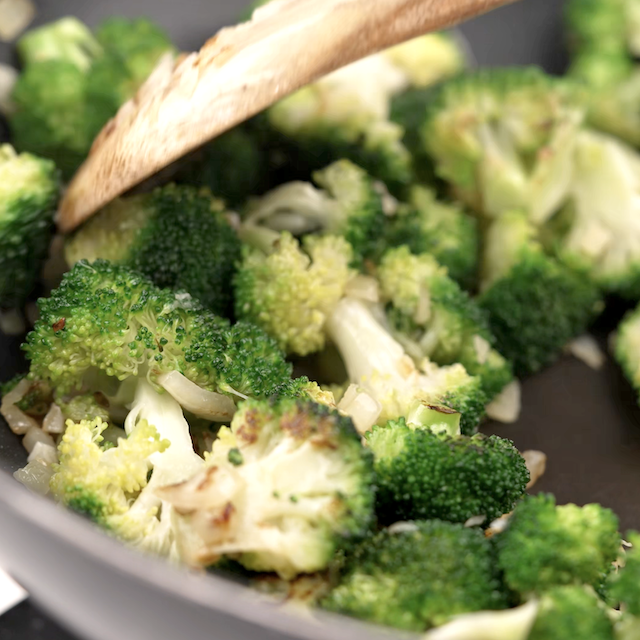 Broccoli being cooked to make beef and broccoli stir fry.