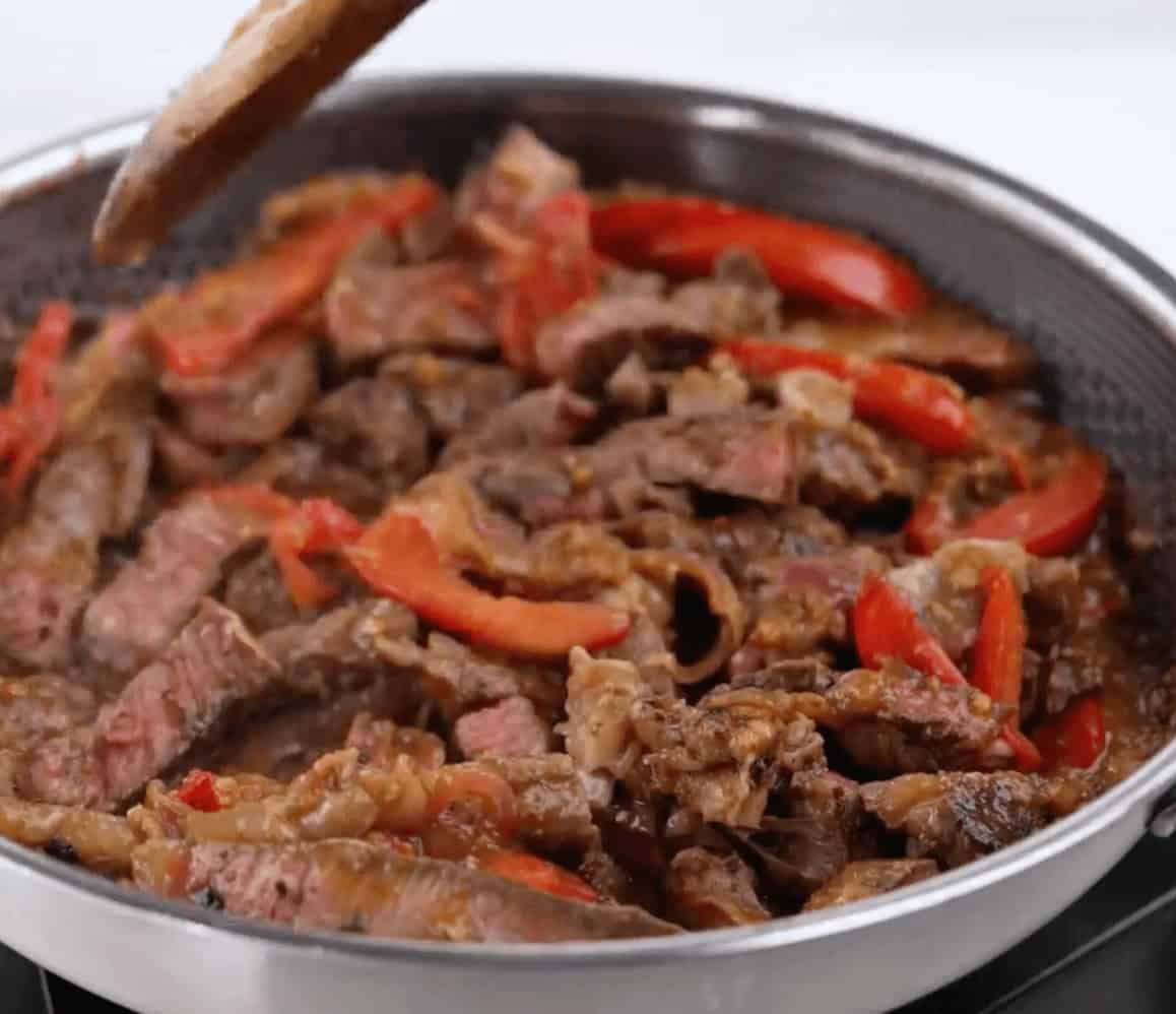 Adding the sliced beef to cook with the rest of the flavors.