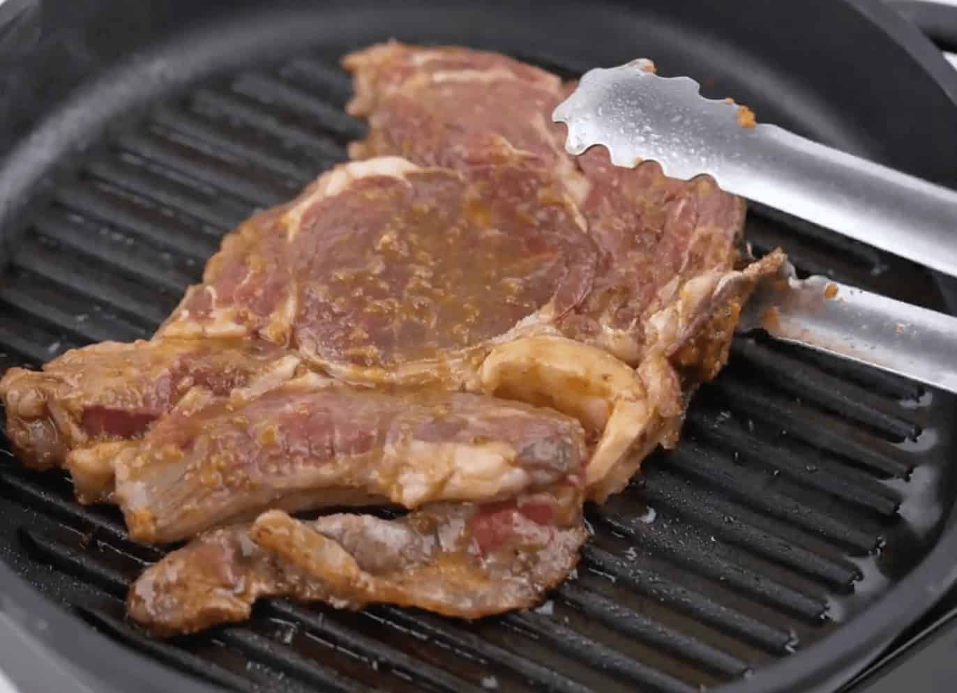 Cooking the steak on a hot grill.