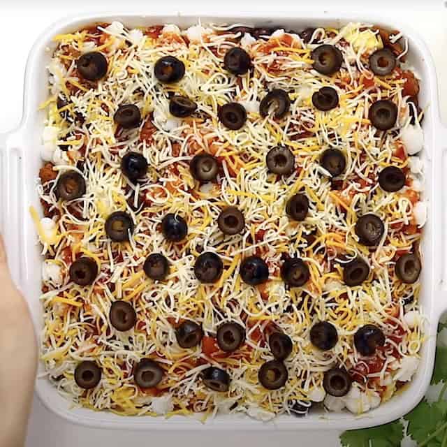 Homemade Mexican breakfast casserole, garnished with black olives, ready to be baked.