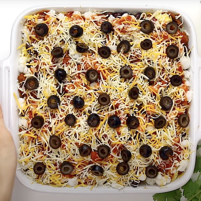 Homemade Mexican breakfast casserole, garnished with black olives, ready to be baked.