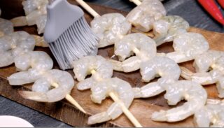 Shrimp skewers threaded on wooden skewer