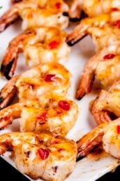 Grilled Shrimp kabobs on a white plate with thai sauce