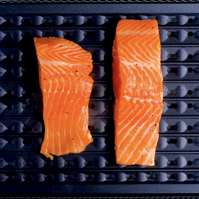 Salmon fillets being cooked on an indoor grill.