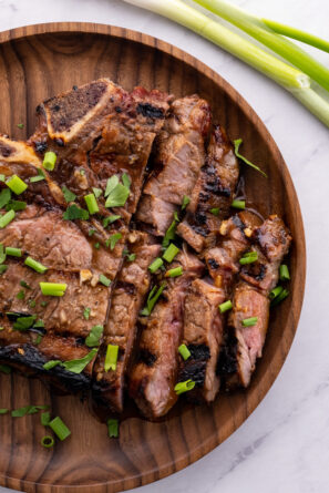 marinated ribeye steaks on a plate sliced