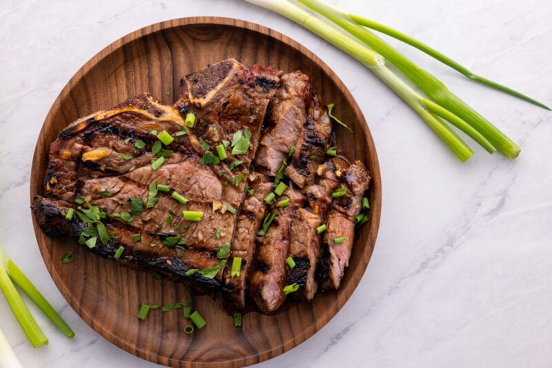 marinated ribeye steaks on a plate sliced