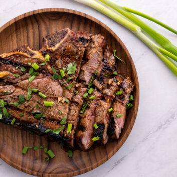 marinated ribeye steaks on a plate sliced