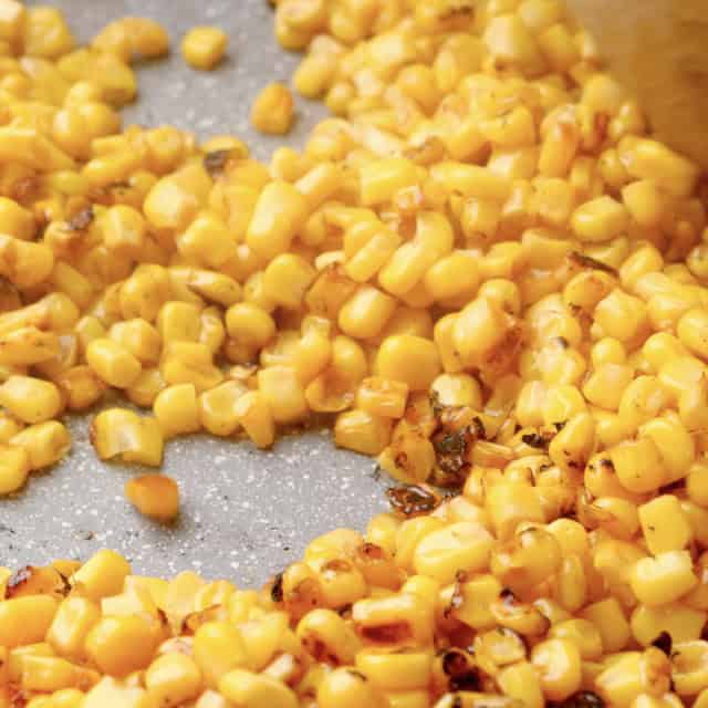 Corn being charred to make Mexican street corn salad, which is also known as esquites.
