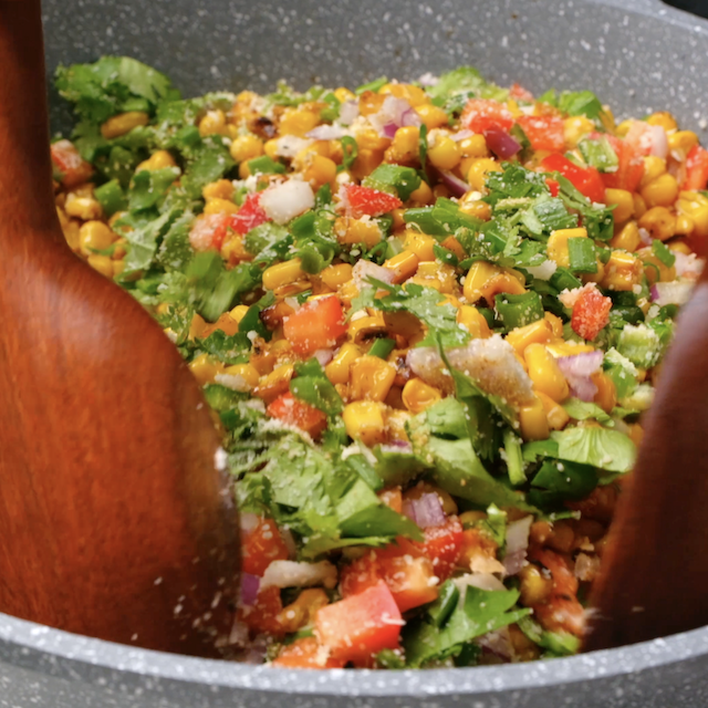 All ingredients to make Mexican street corn salad being combined in a pan.