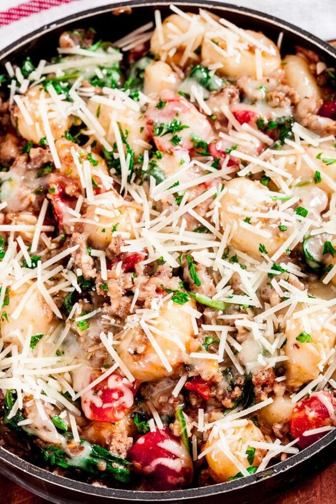gnocchi with sausage, spinach, and tomatoes in a pan