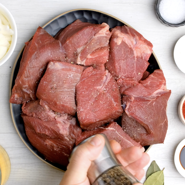 Beef roast pieces being seasoned on both sides to make instant pot roast beef.