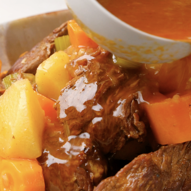 Thickened gravy being poured over roast beef to make instant pot roast beef at home.