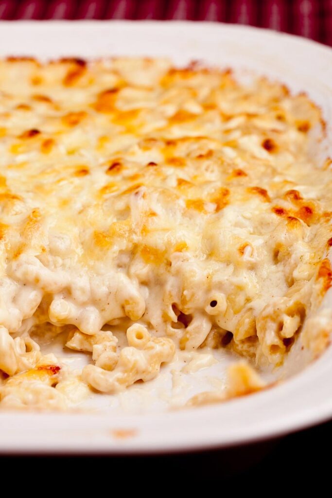 baked macaroni and cheese in white dish vertical