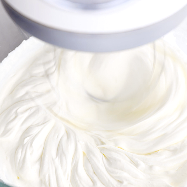 Cream being whipped until soft peaks to make triple chocolate mousse cake layer.