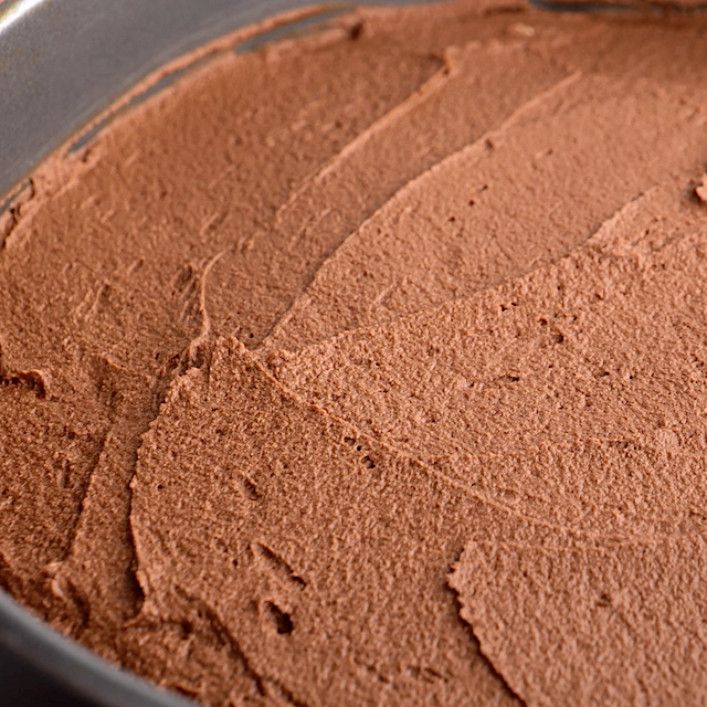 Middle layer of triple chocolate mousse cake in a springform pan, ready to be chilled.