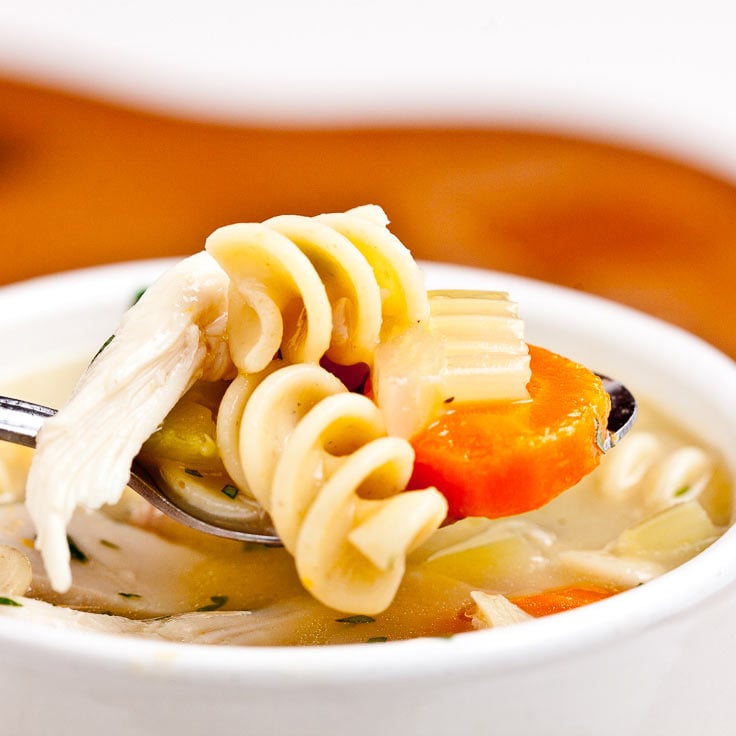 chicken noodle soup in bowl with spoon