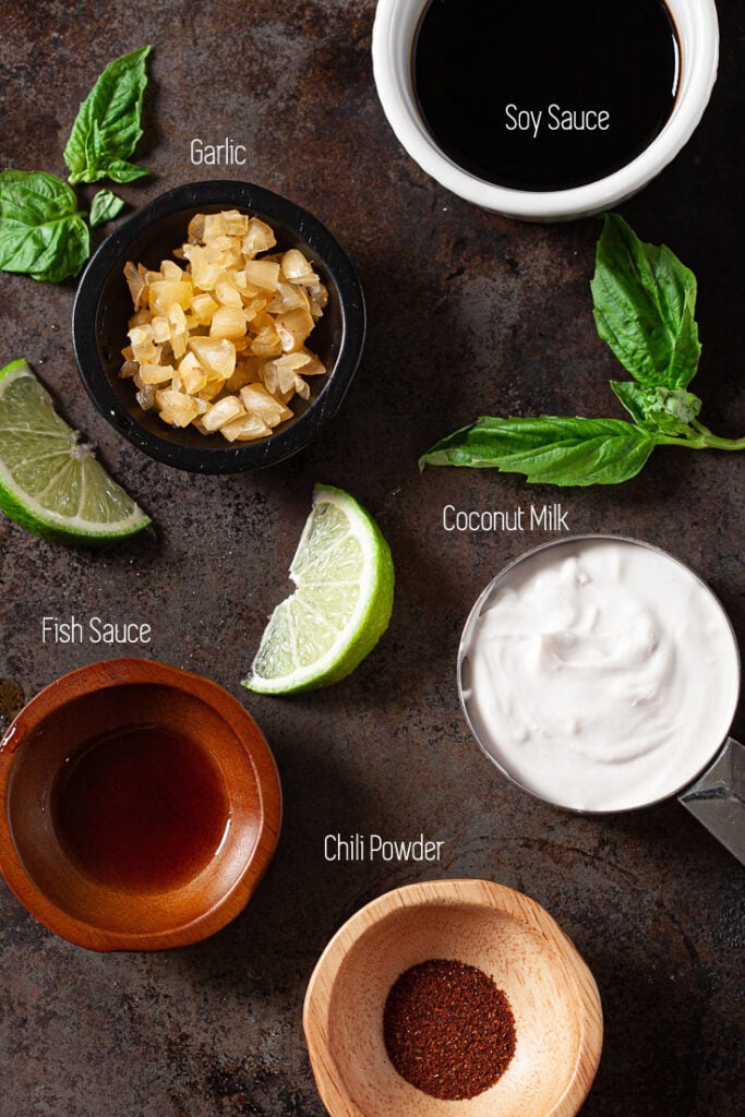 Ingredients in Thai chicken and rice dish, including garlic, fish sauce, soy sauce, coconut milk, and chili powder