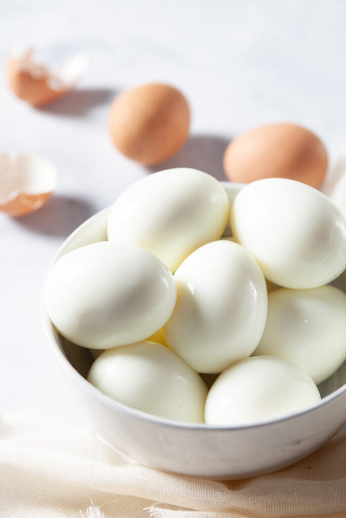 Boiled eggs in white bowl vertical