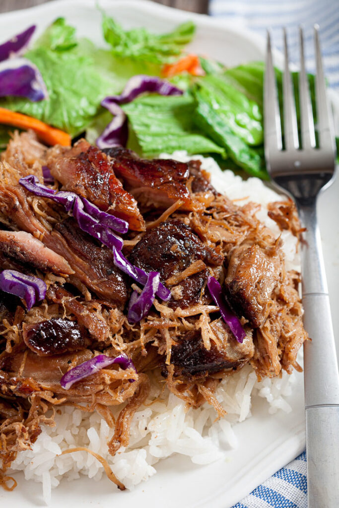 Kalua Pork shredded over rice on plate