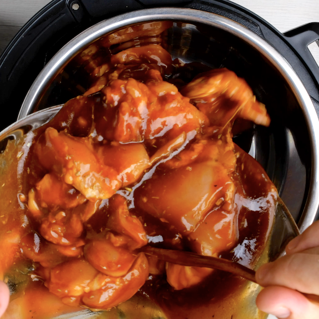 Chicken and sauce mixture being transferred to slow cooker to make bbq pulled chicken.