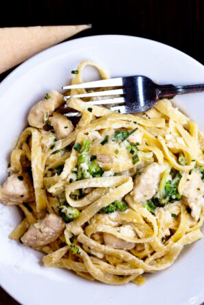 Fettuccini Alfredo with chicken and broccoli on white plate