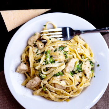 Fettuccini Alfredo with chicken and broccoli on white plate