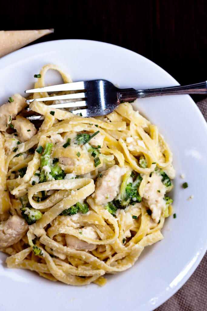 fettuccini alfredo with chicken and broccoli in white plate