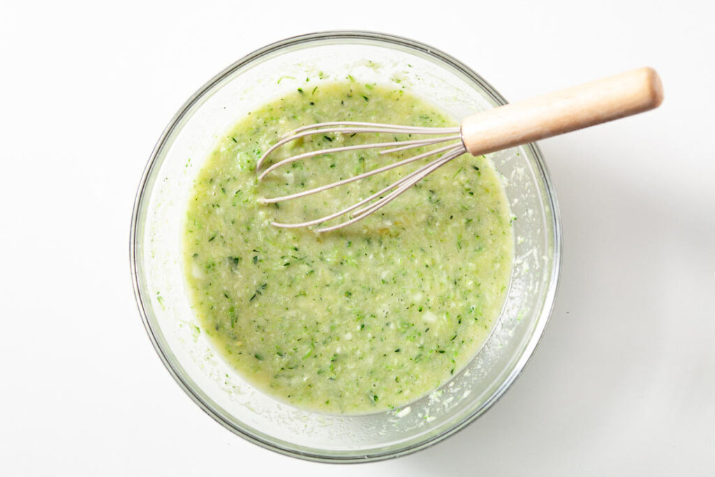 zucchini bread mixed ingredients in bowl with whisk