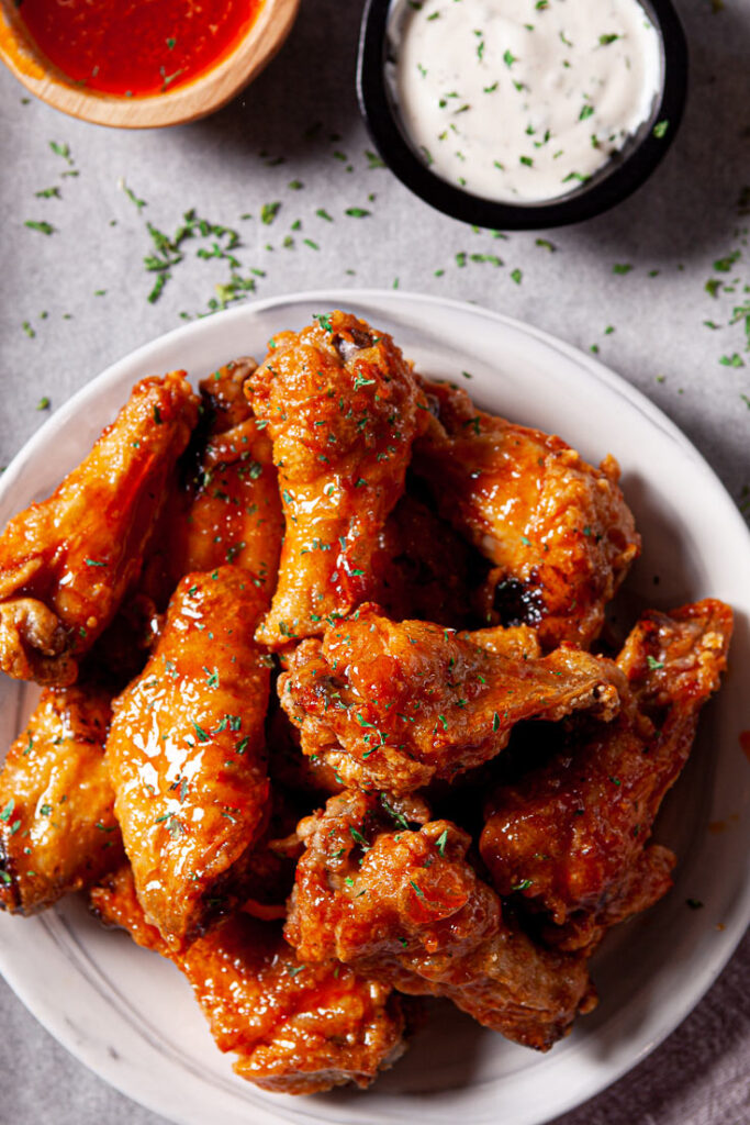 Air Fryer Chicken Wings on white plate with buffalo sauce