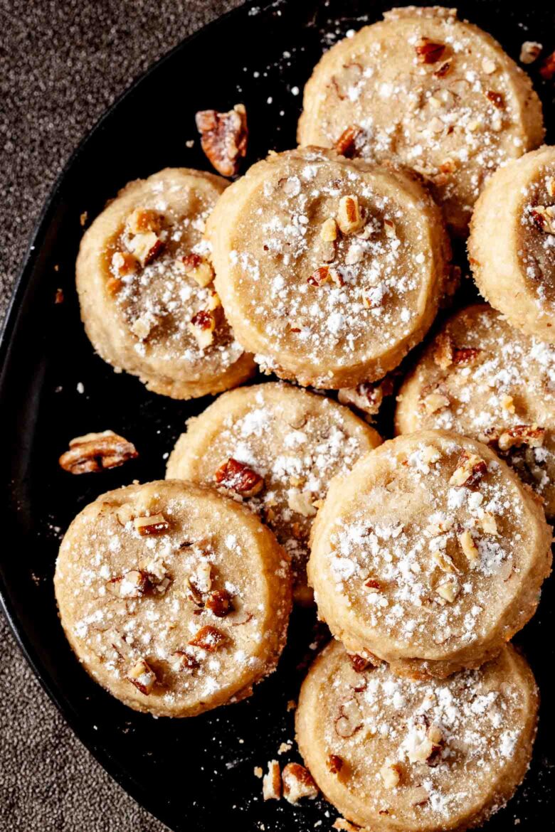 pecan sandies on a black plate.