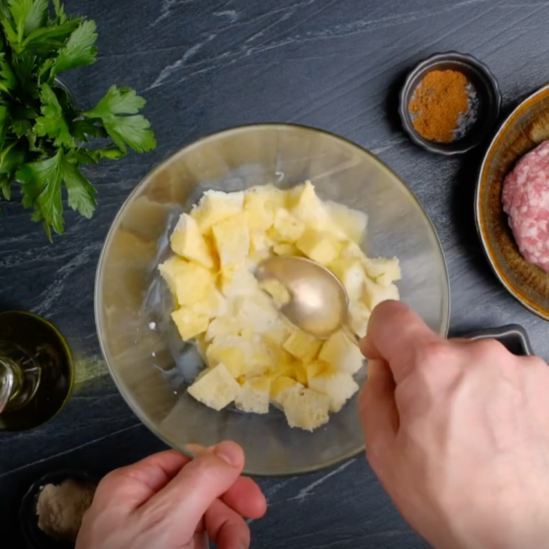 Overhead shot of chopped bread, milk, and beaten egg being mixed to make Swedish meatballs.