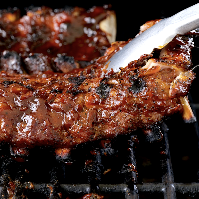Sauced ribs being grilled on both sides to make tender BBQ ribs.