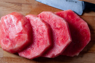 watermelon being sliced into rounds
