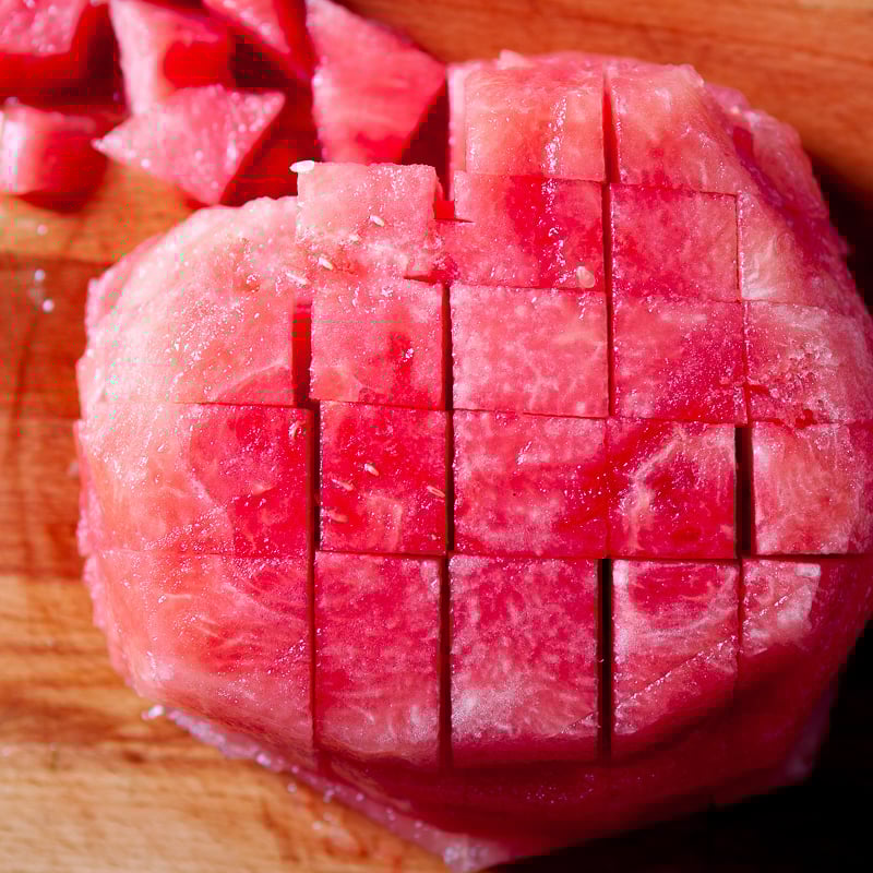 Stacked watermelon rounds cut into cubes.
