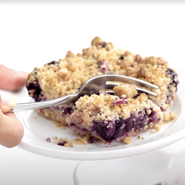 A fork slicing into homemade blueberry crumb bar.