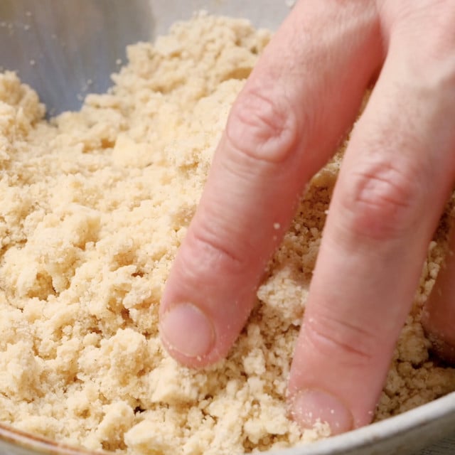 Streusel for blueberry coffee cake being mixed by hand.