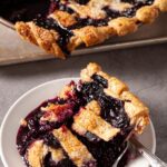 blueberry pie sliced on a white plate