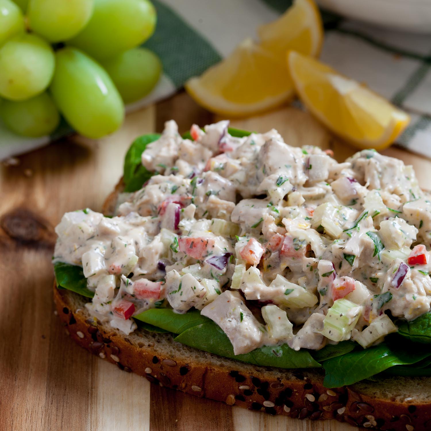 chicken salad layered on a piece of bread with greens