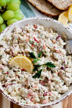 overhead image of healthy chicken salad in a bowl topped with a lemon wedge