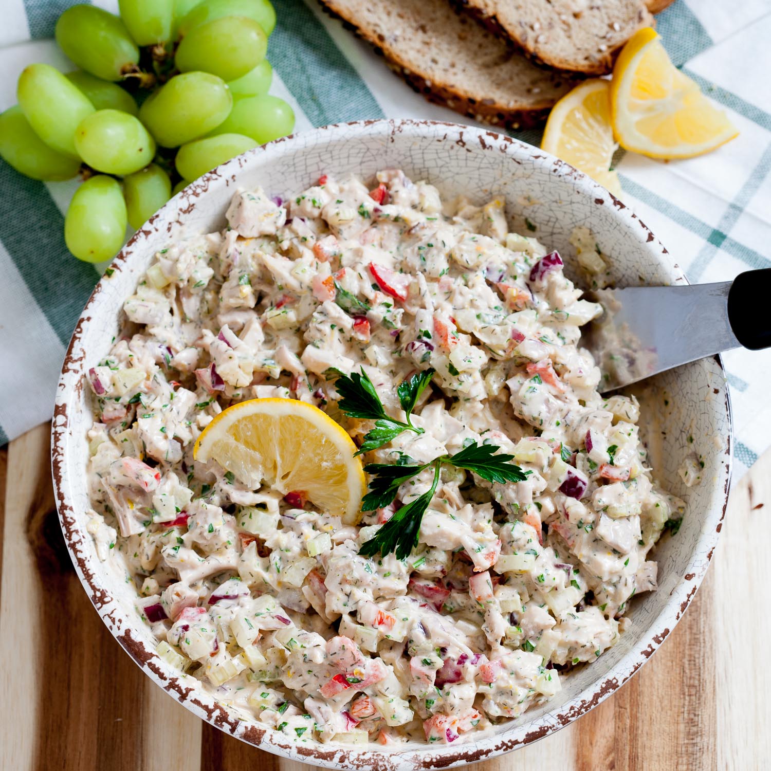 overhead image of healthy chicken salad in a bowl topped with a lemon wedge