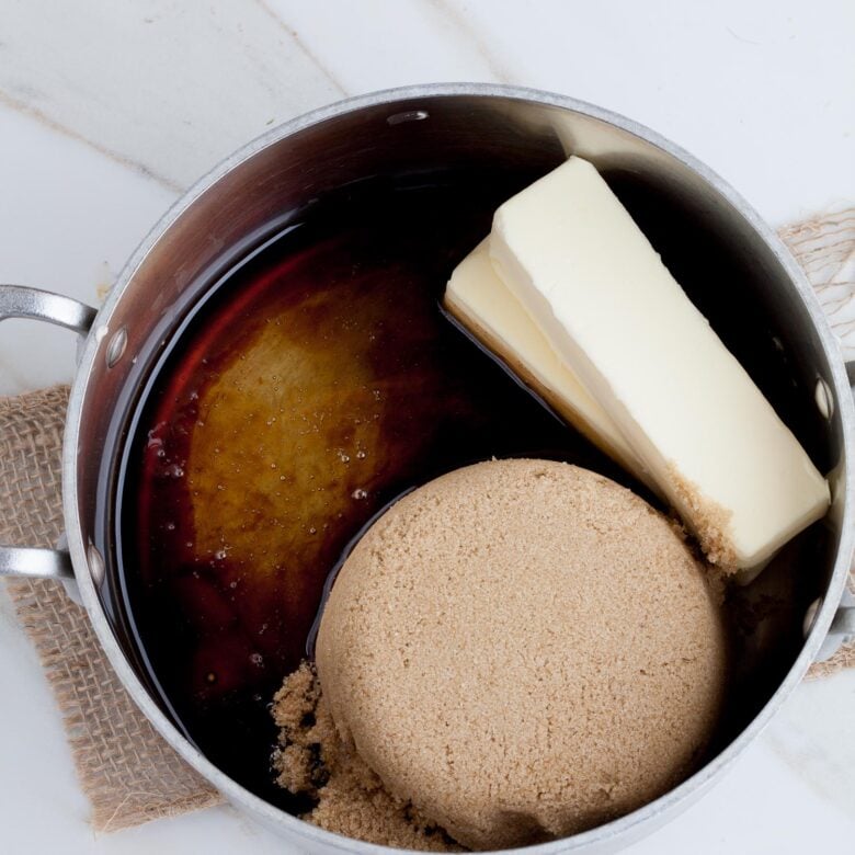 butter, sugar, and other ingredients in a pot to make caramel