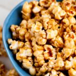 a blue bowl full of caramel popcorn