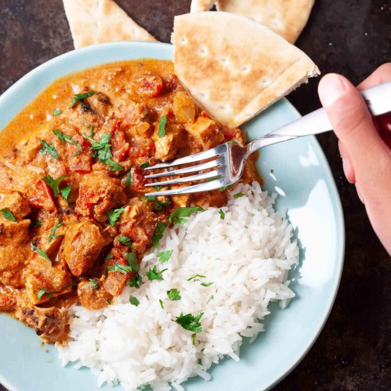 chicken tikka masala served with rice close up.