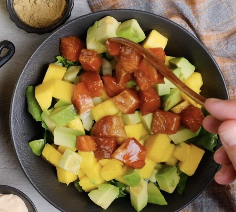 Poke Bowl being layered into serving bowl.