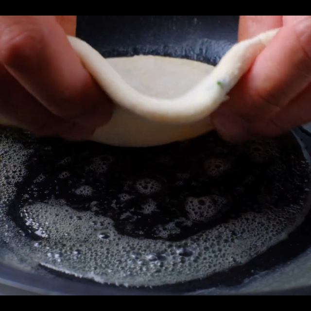 scallion pancakes being pan fried.