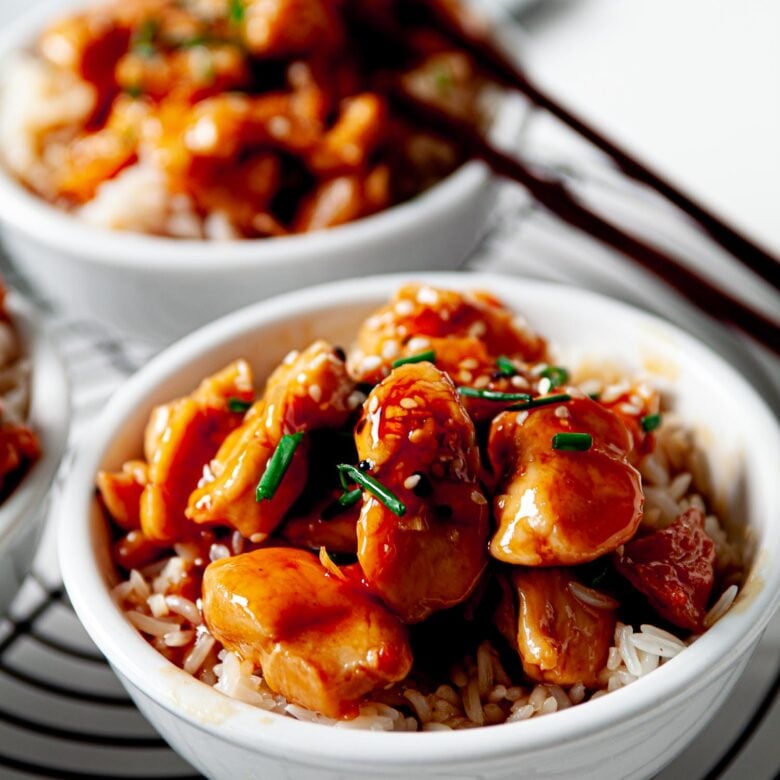 two bowls of rice topped with teriyaki chicken