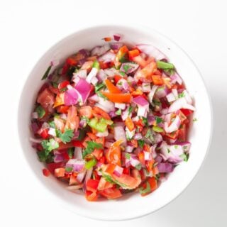 chopped tomatoes, red onions, and cilantro in a white bowl for shrimp ceviche