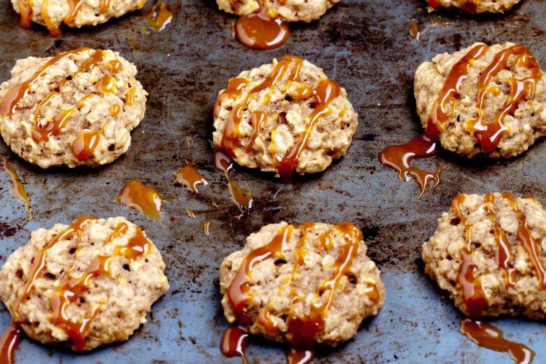 soft apple oatmeal cookies on a baking sheet with homemade caramel