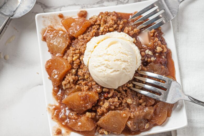 eating a fall apple crisp with vanilla ice cream and forks